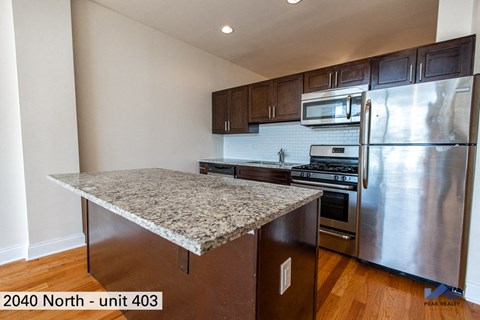 an updated kitchen with stainless steel appliances and granite counter tops