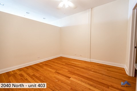 the living room of a home with wood floors and white walls