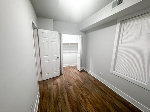 A room with a white door and a window with blinds.