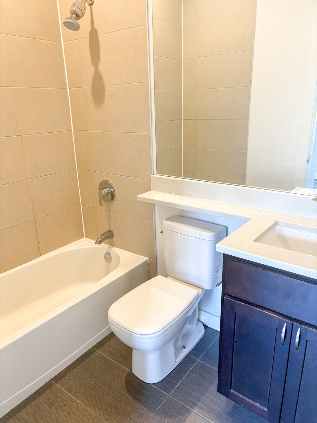 A white toilet sits next to a white bathtub in a bathroom.