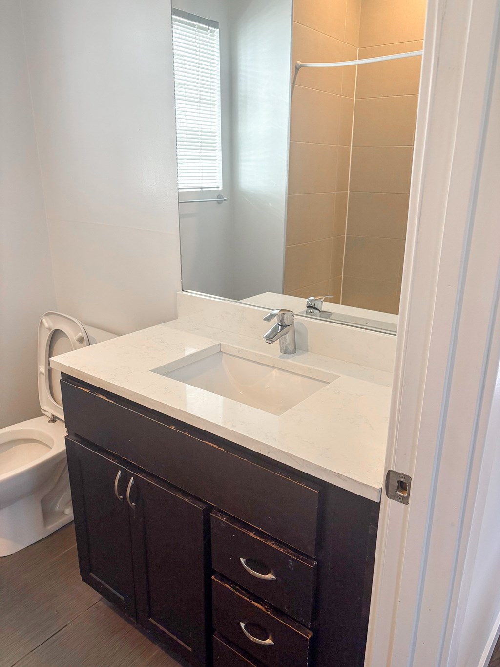 A white sink in a bathroom with a white counter top and a white toilet.