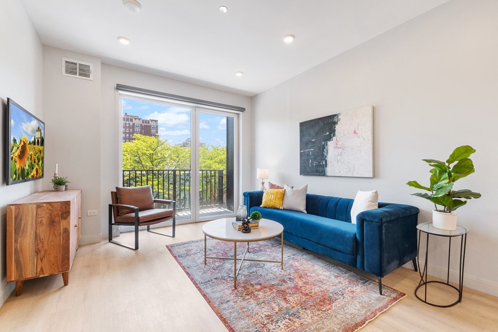 a living room with a blue couch and a large window