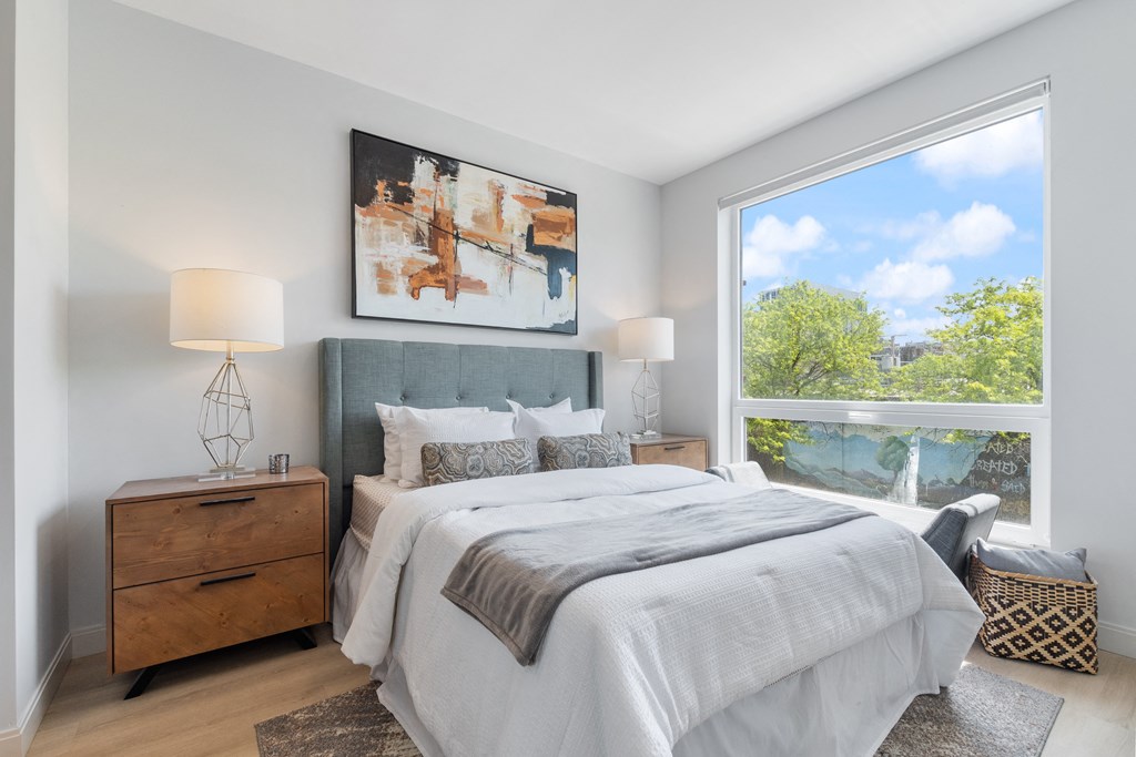 a bedroom with a large window and a large bed