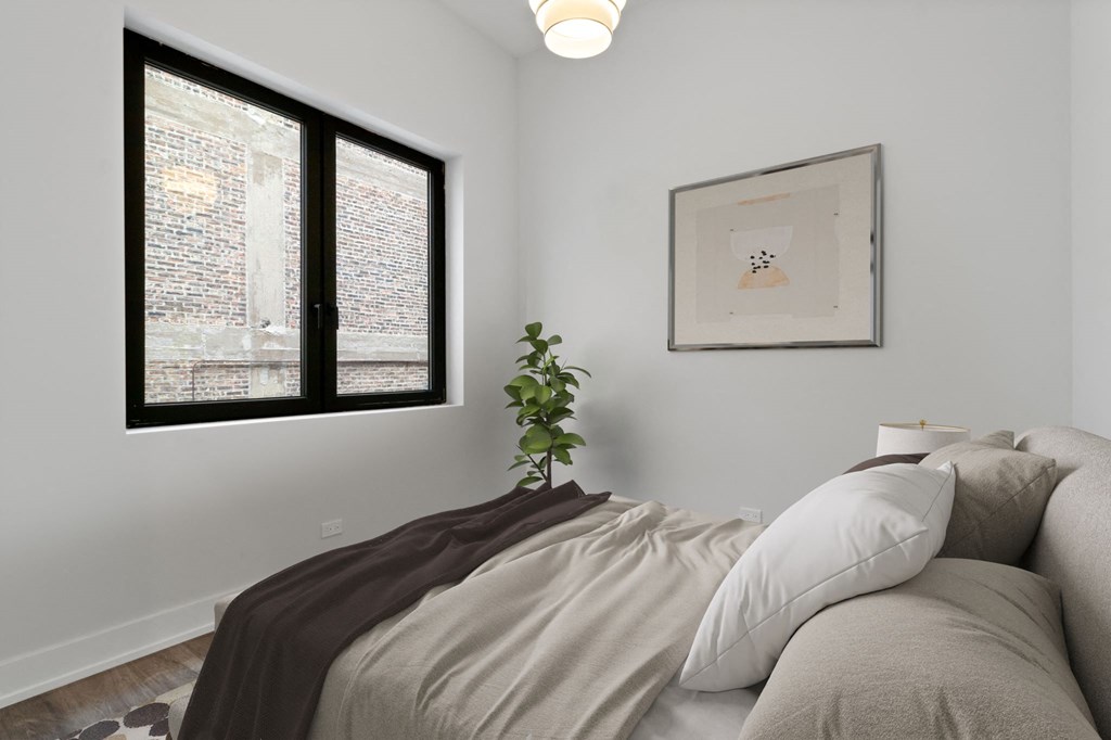 a bedroom with a large bed and two windows