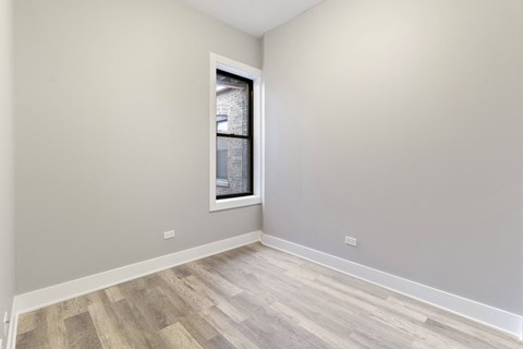 an empty room with wood floors and a window