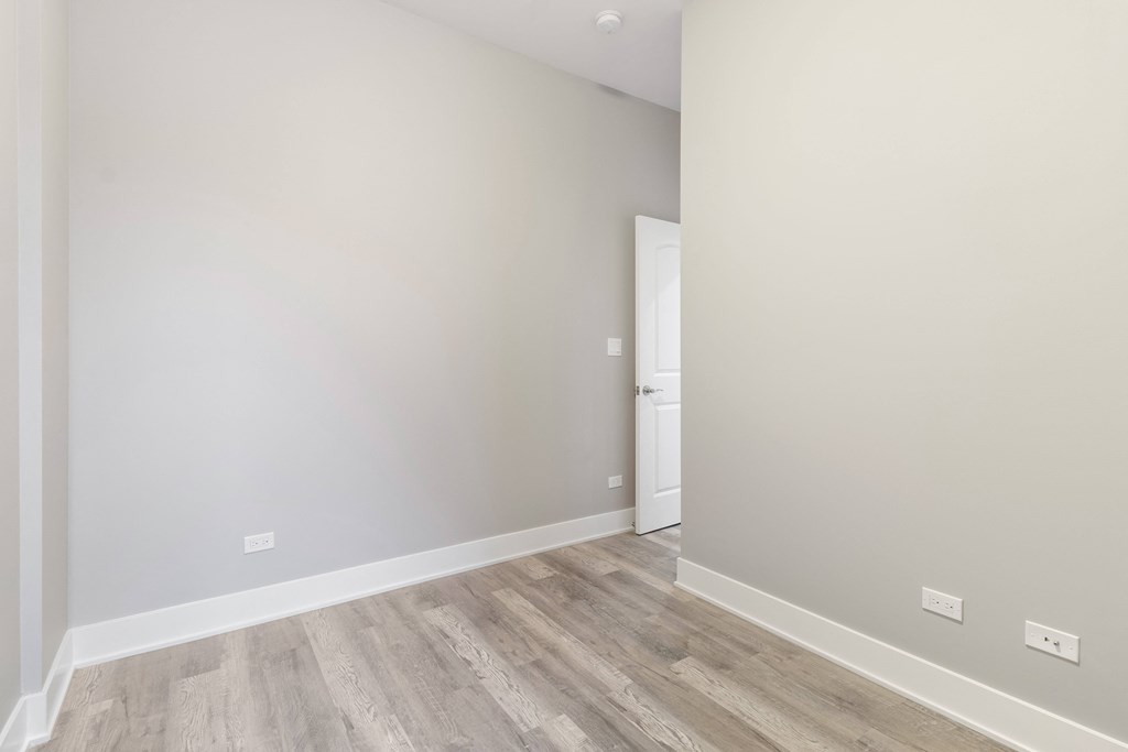 a room with white walls and wood flooring and a doorway