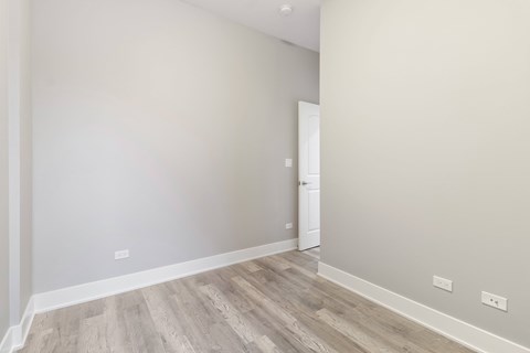 a room with white walls and wood flooring and a doorway