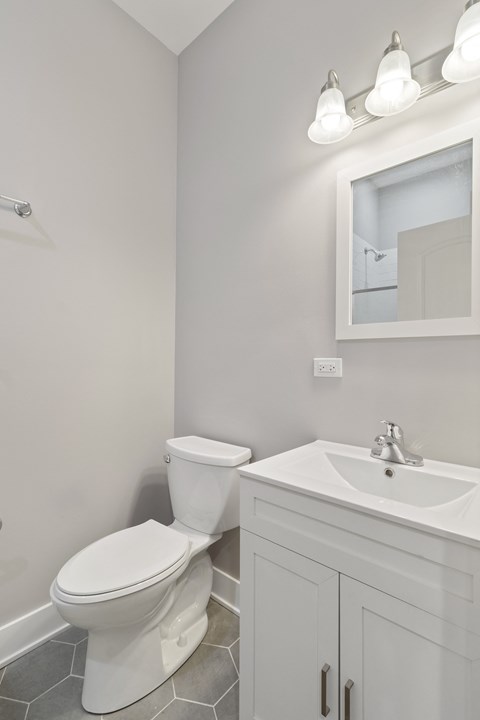 a white bathroom with a toilet and a sink