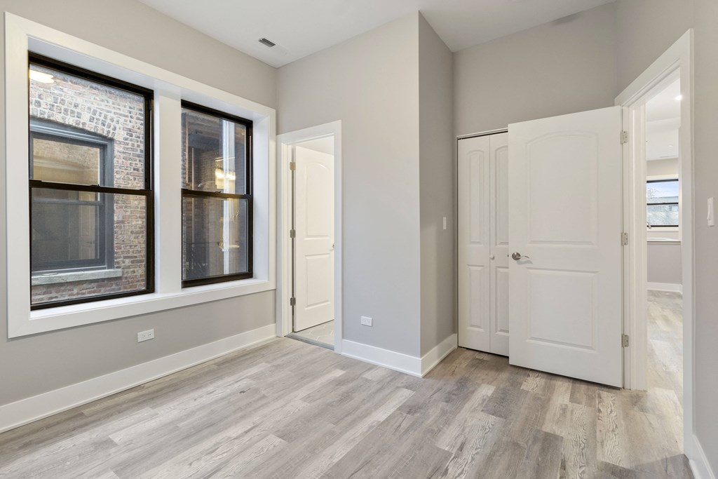 an empty room with a door and a window and a door to a closet