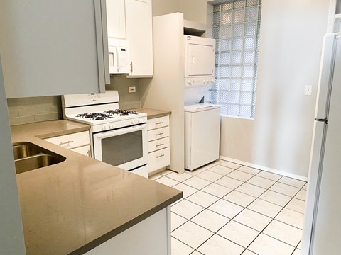 A kitchen with white appliances and a stainless steel sink.