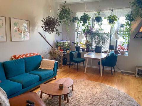 A living room with a blue couch and a table with a candle on it.