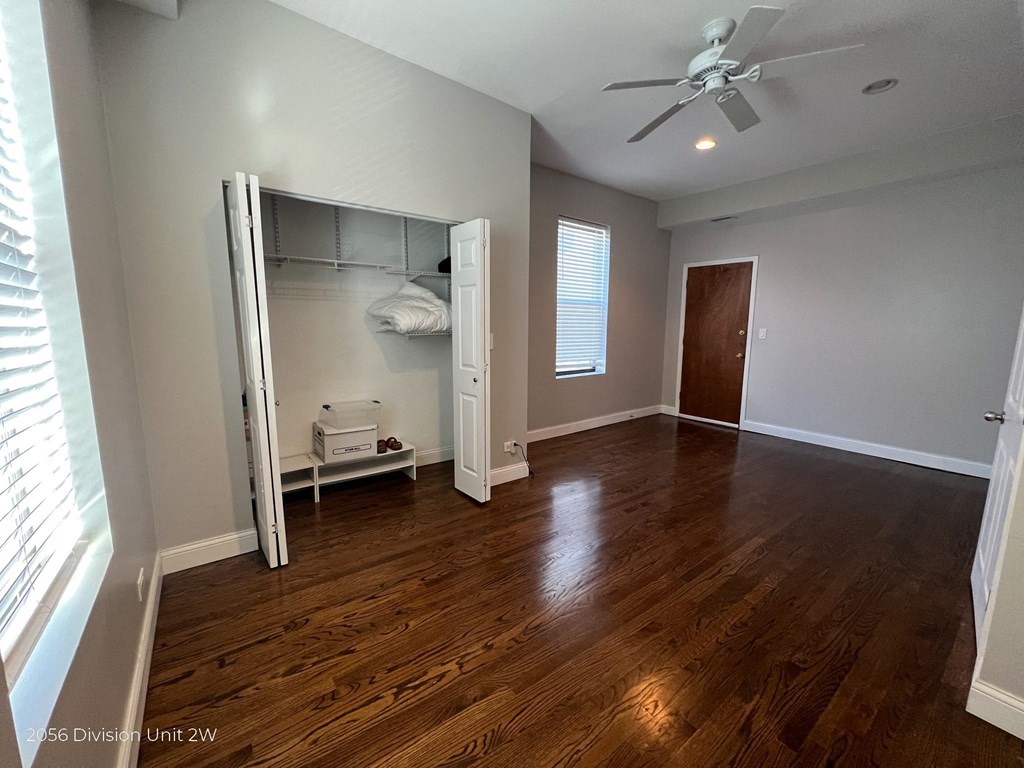 an empty bedroom with a closet and a ceiling fan
