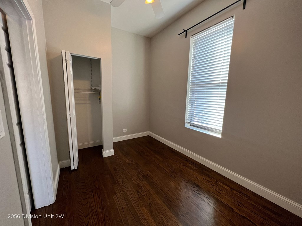 an empty room with wooden floors and a closet