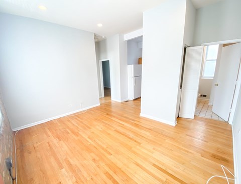 A room with wooden flooring and white walls.