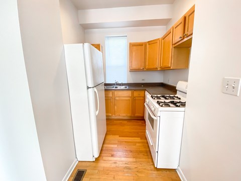 A kitchen with a white refrigerator and a white stove.