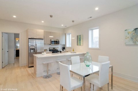 A modern kitchen with a dining table and chairs.