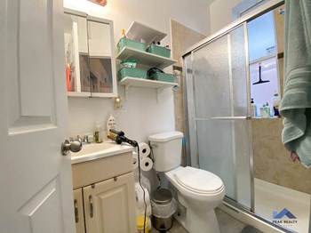 a bathroom with a toilet sink and shower - Photo Gallery 6