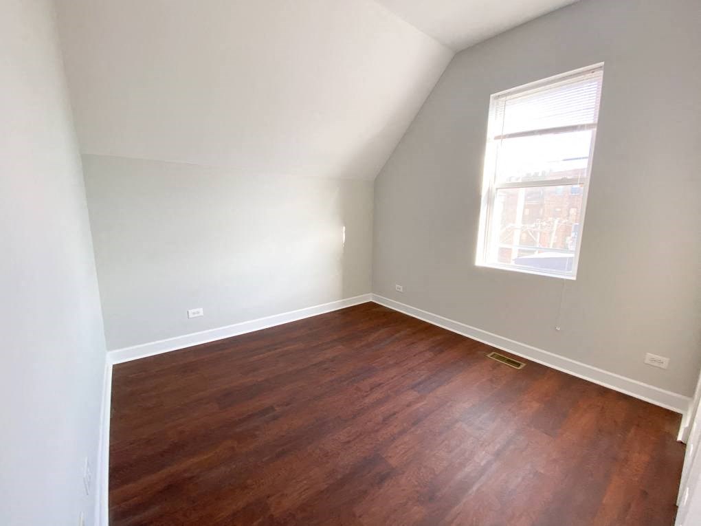 a empty room with wooden floors and a window