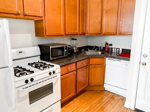 A kitchen with wooden cabinets and a white stove.