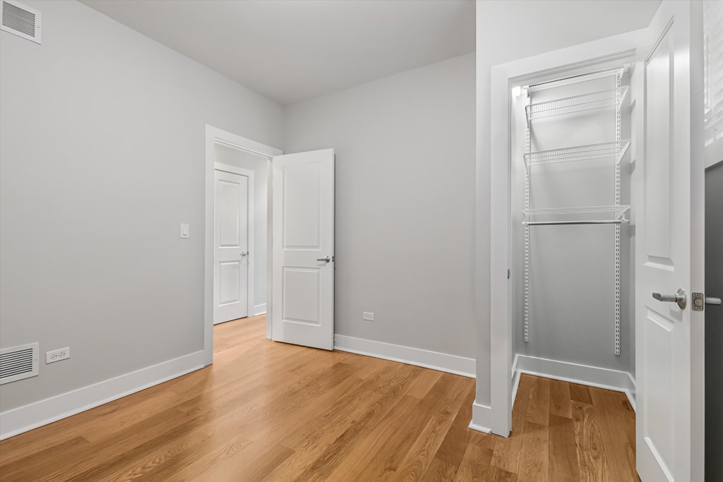 A white room with a wooden floor and a white door.