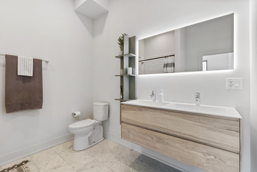 Modern bathroom with a toilet sink and LED mirror