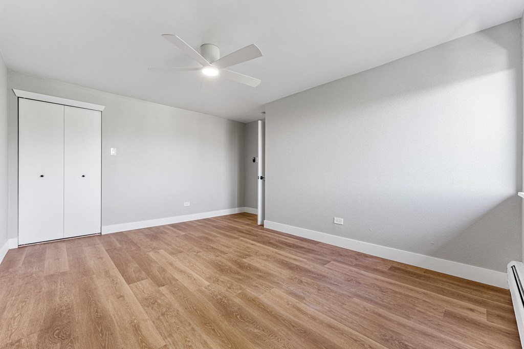 a living room with white walls and a ceiling fan