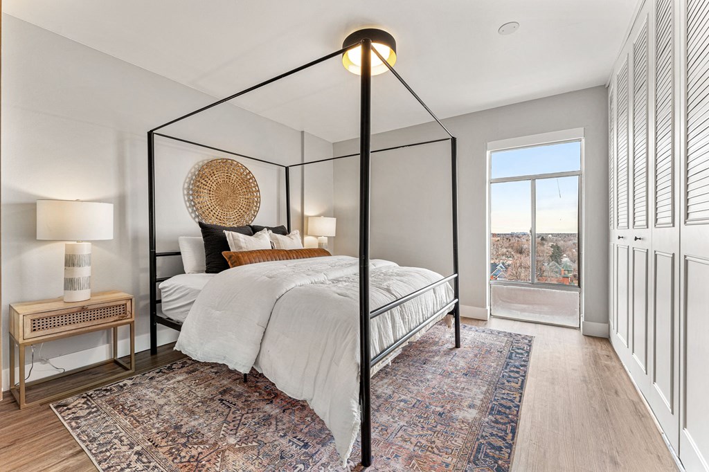 a bedroom with a large bed, lots of closet space, and a large window