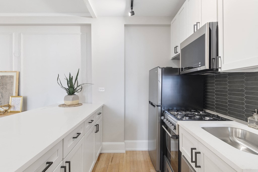 a kitchen with a stove and a microwave and a sink