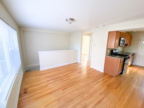 an empty kitchen and living room with wood flooring