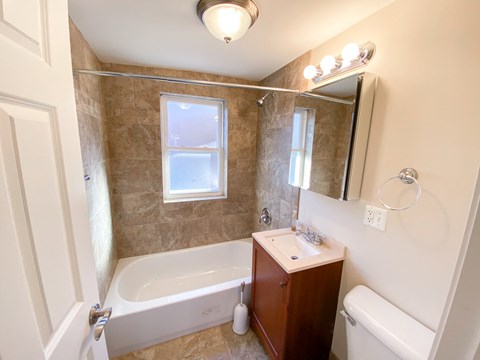 a bathroom with a tub and a sink and a mirror