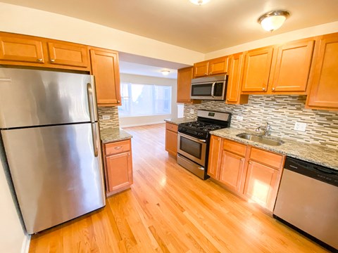 a kitchen with stainless steel appliances and wooden cabinets