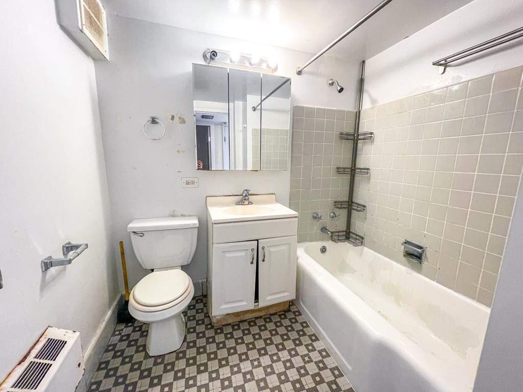 A white toilet sits next to a sink in a bathroom.
