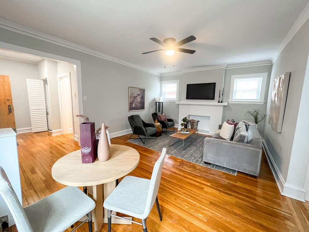 A living room with a white ceiling fan and a grey couch.