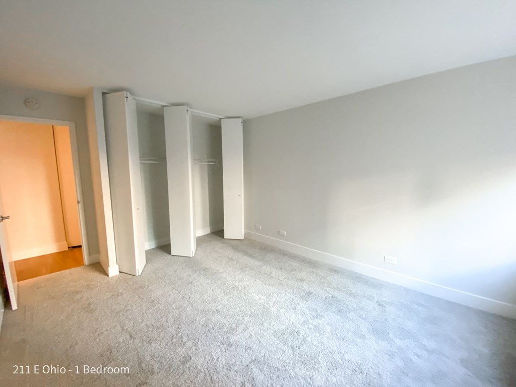 an empty living room with white carpet and white walls