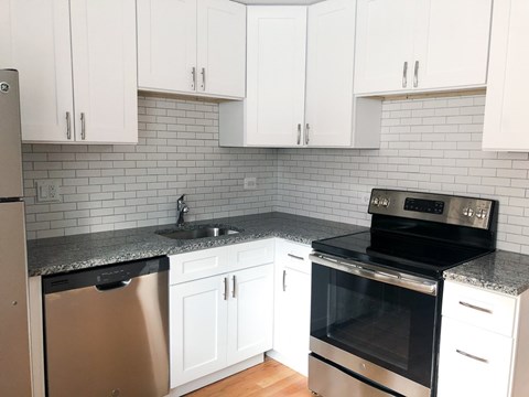 A kitchen with white cabinets and a black oven.