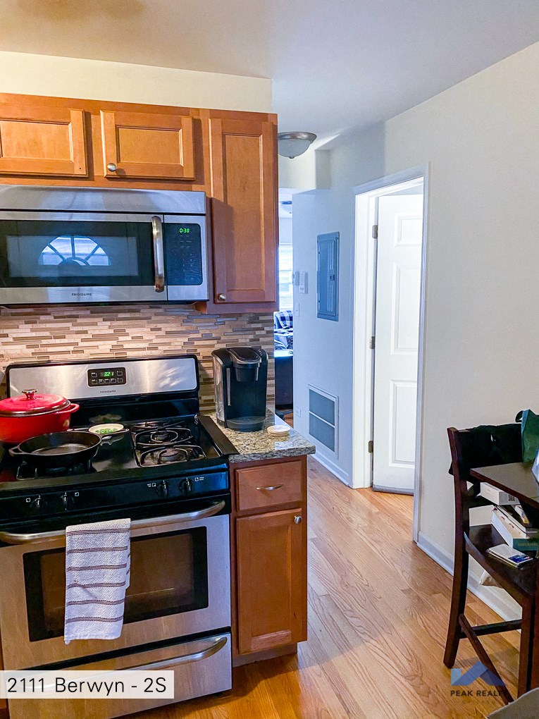 a kitchen with wooden cabinets and a stove and a microwave