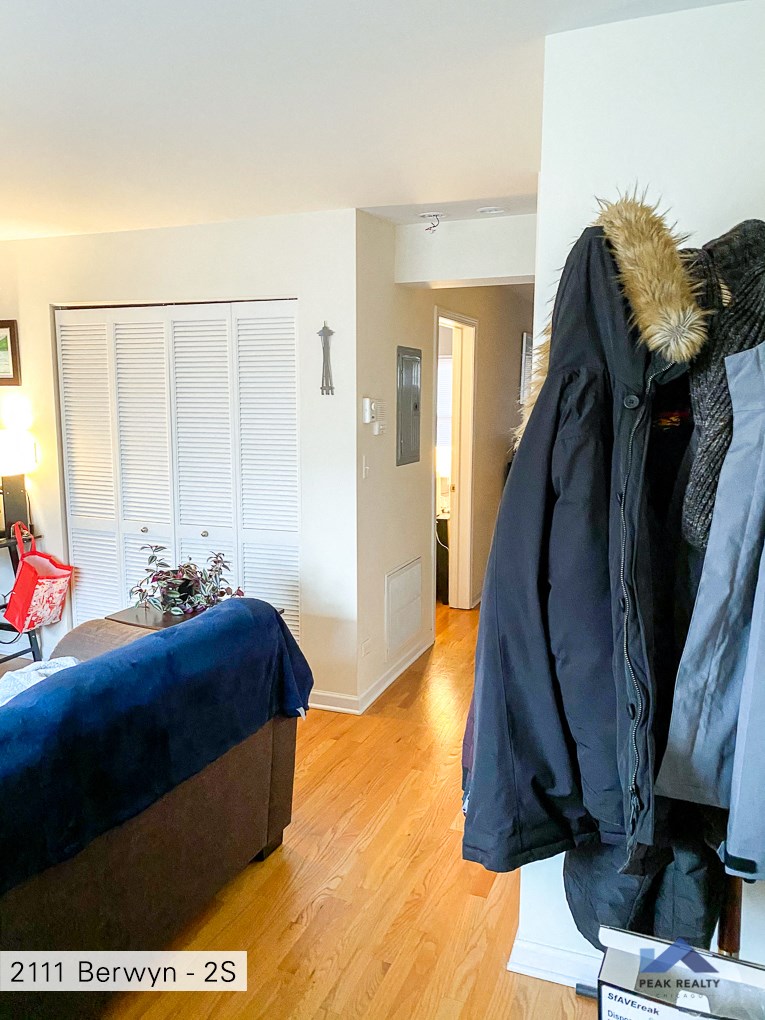 a living room with a couch and a coat hanging on the wall