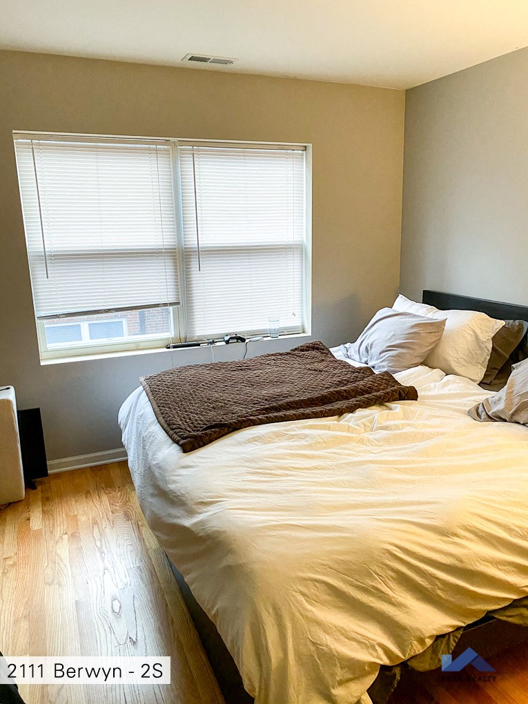 a bedroom with a bed and two windows