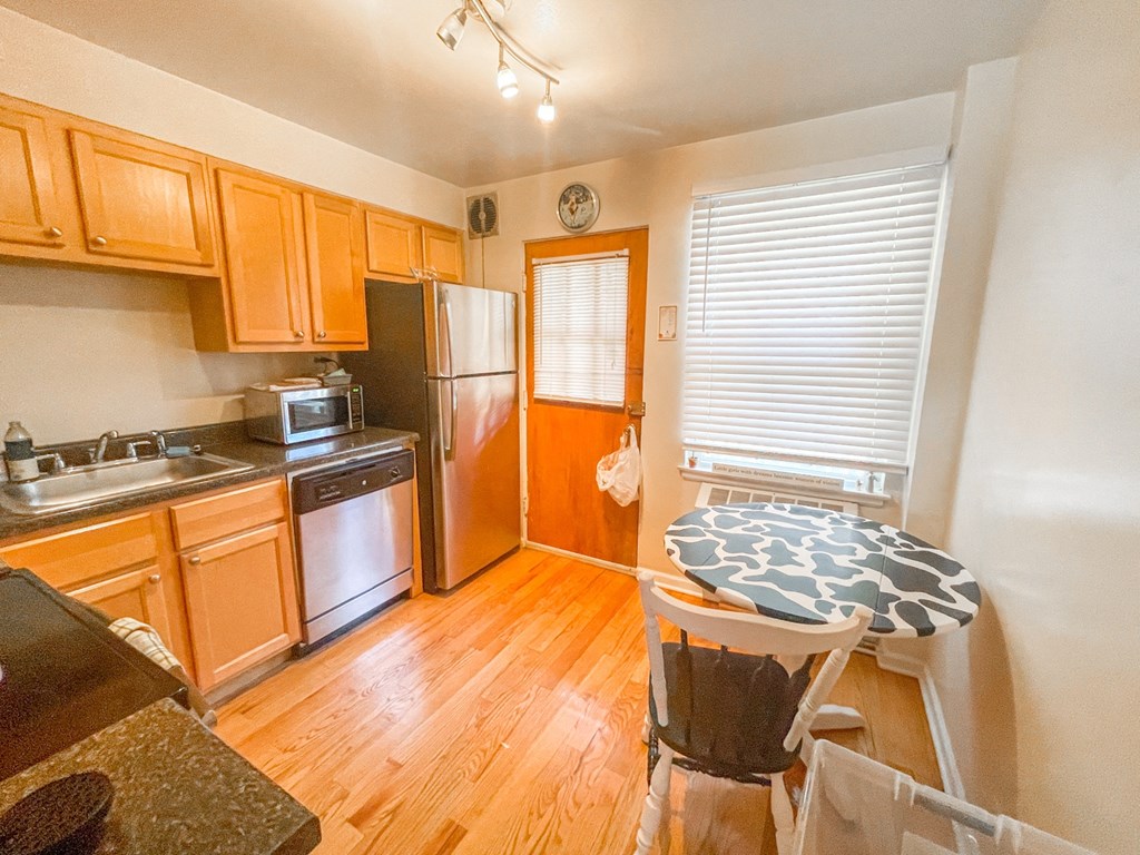 a kitchen with wood floors and wooden cabinets