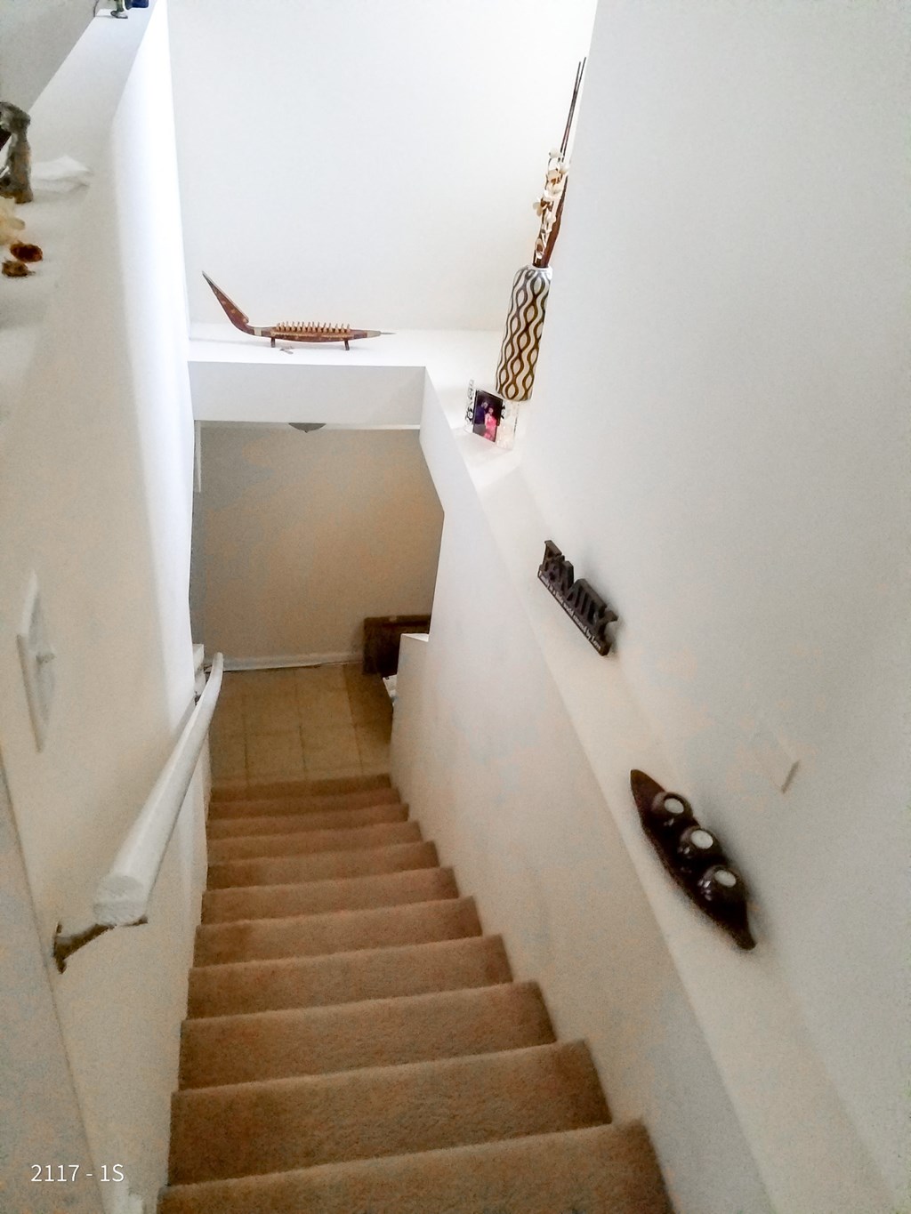 stairs in a house with a stair case and some shoes on the wall