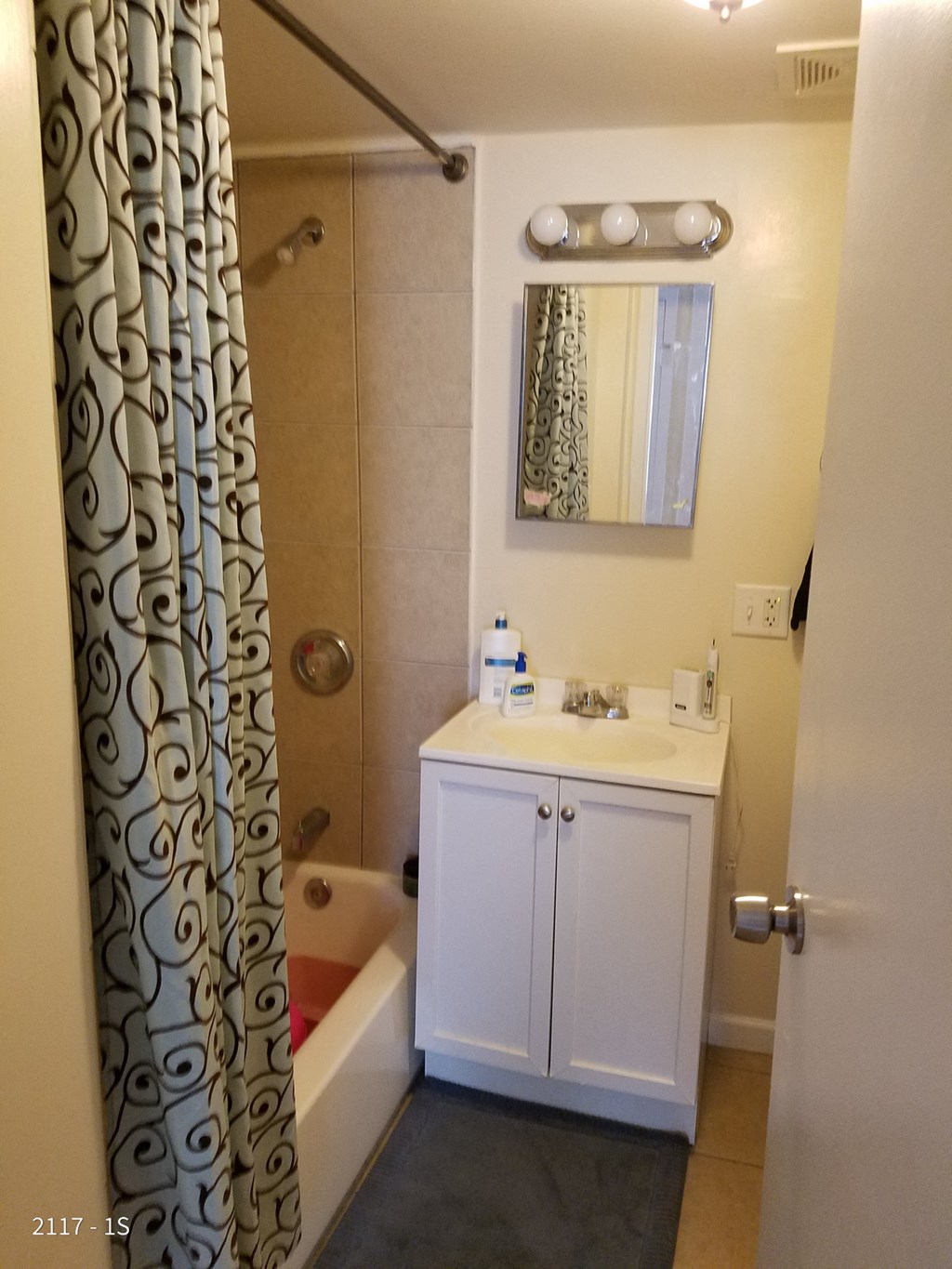a bathroom with a sink and a shower and a curtain