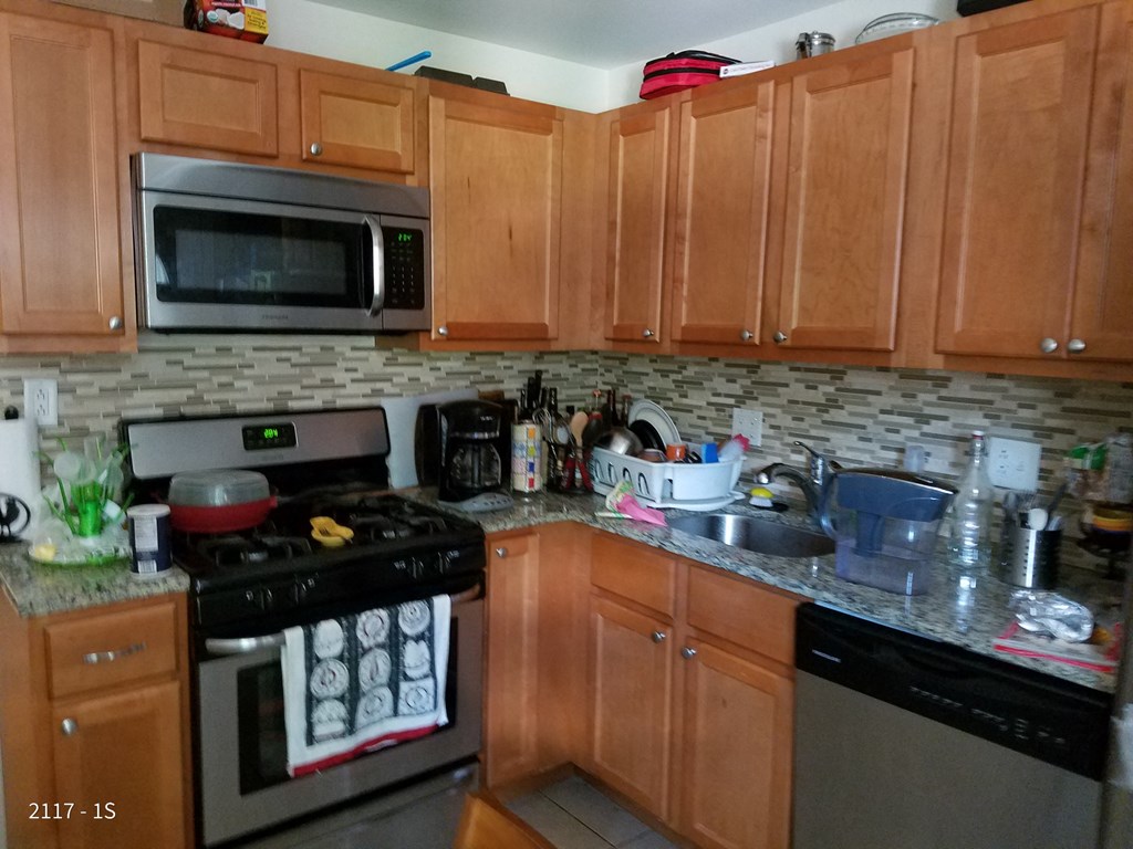 a kitchen with wooden cabinets and a stove and a sink