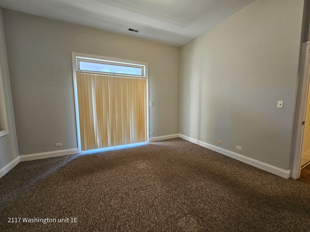 an empty living room with a window and a curtain