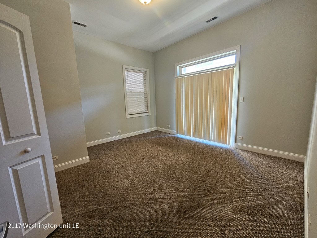 an empty living room with a window and a door