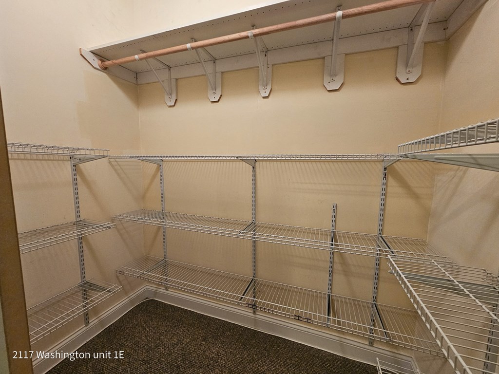 a walk in closet with empty shelves