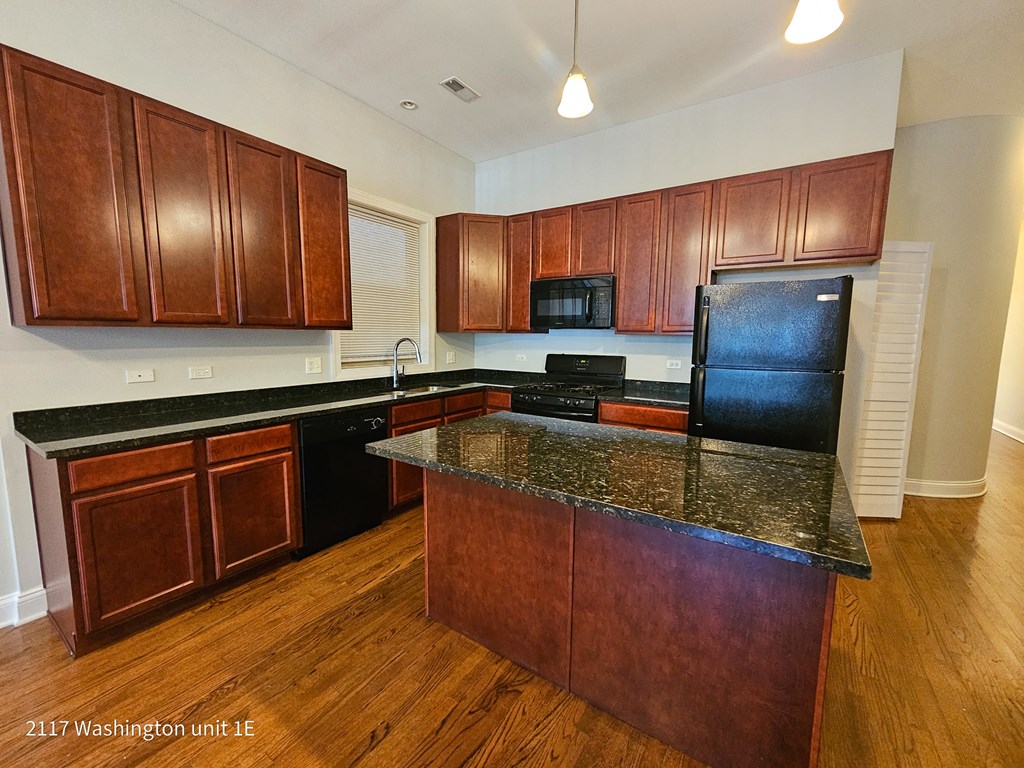 a kitchen with wooden cabinets and a granite counter top