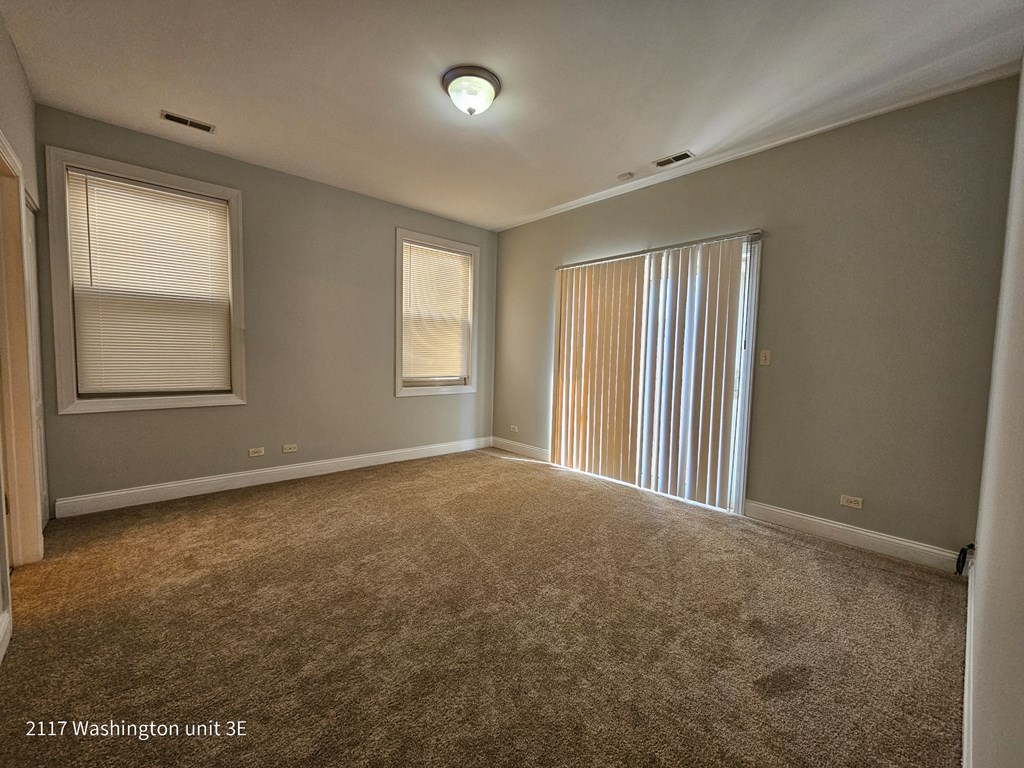 an empty living room with blinds on the window