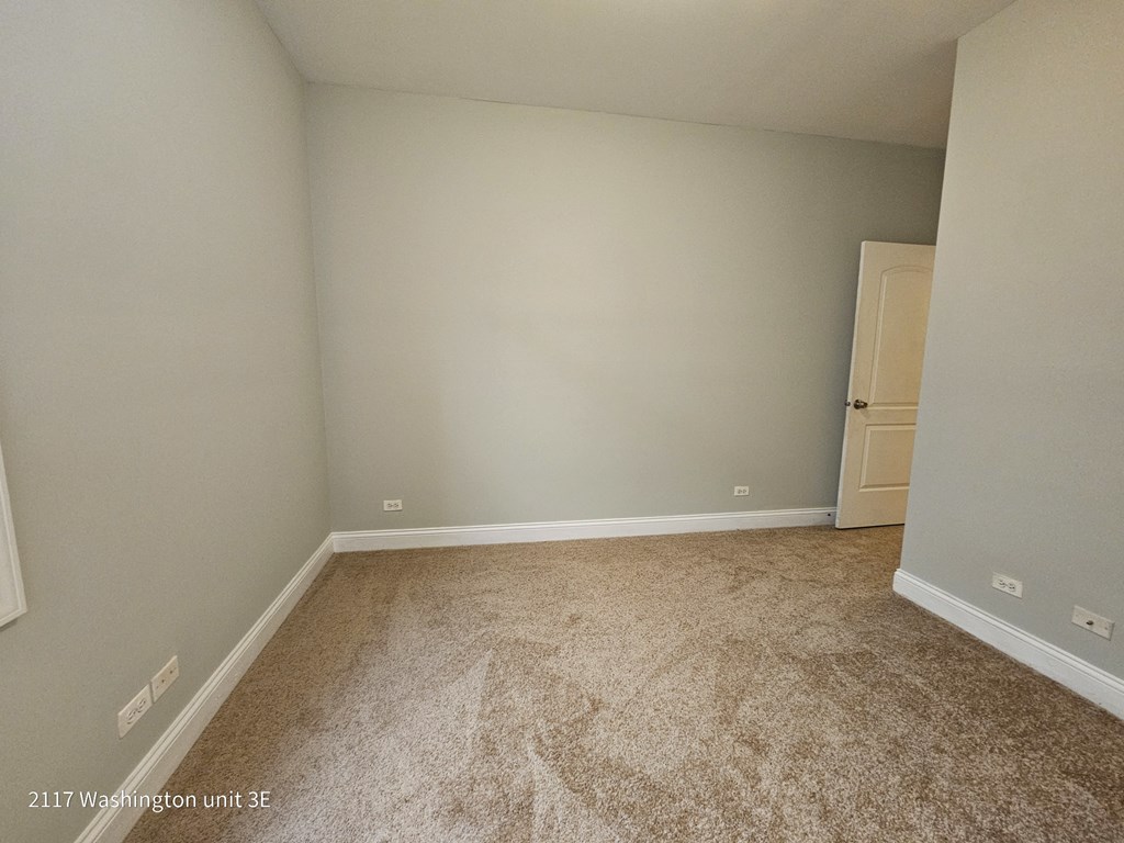 an empty room with a carpeted floor and white walls