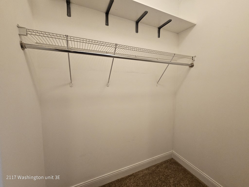 a closet with a hanging rack on the wall
