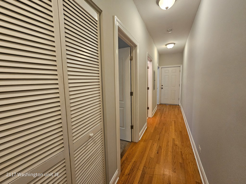 a hallway with closet doors and a door to a bedroom